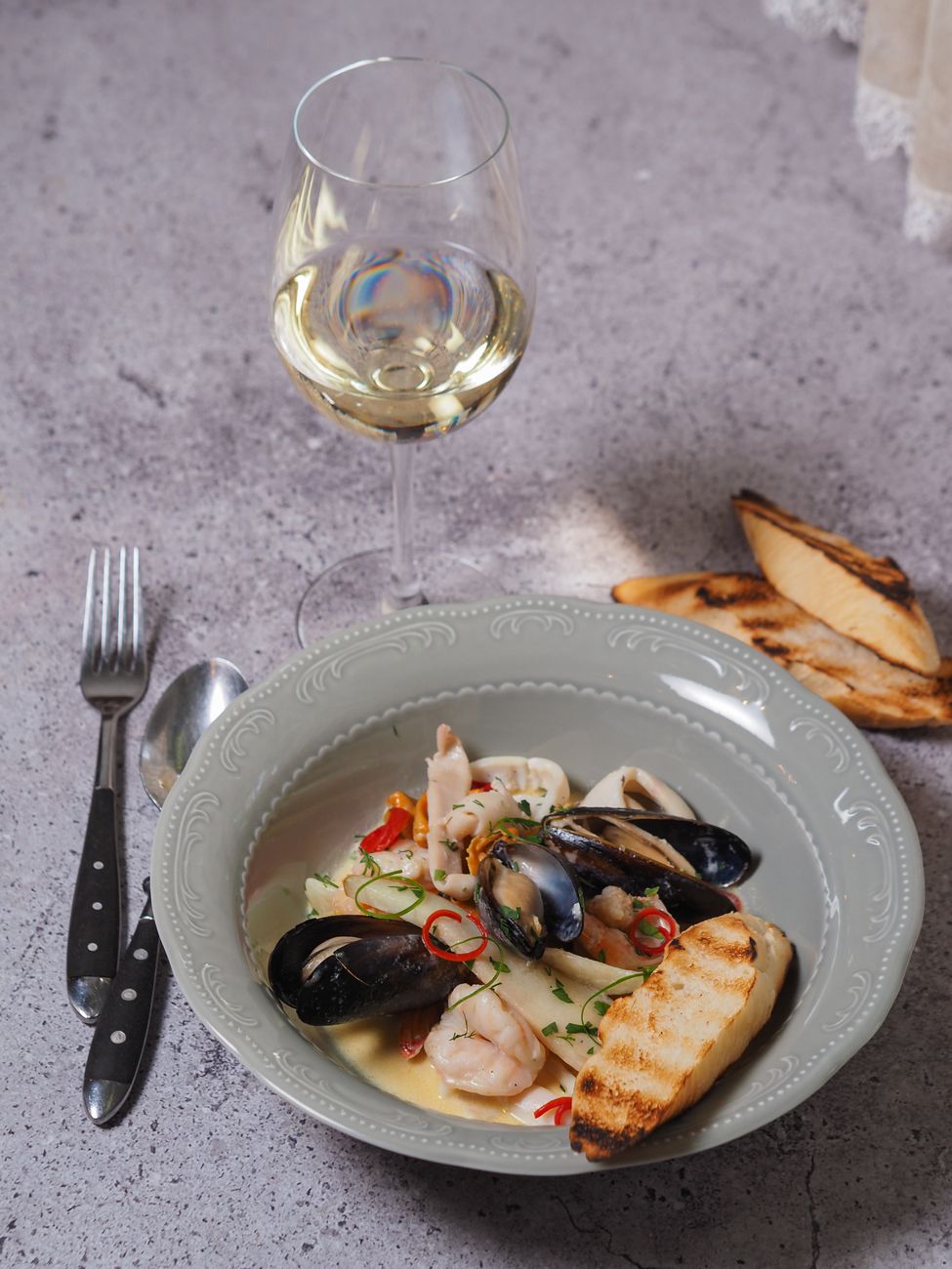 Coastal grill and sparkling white wine on Basque table